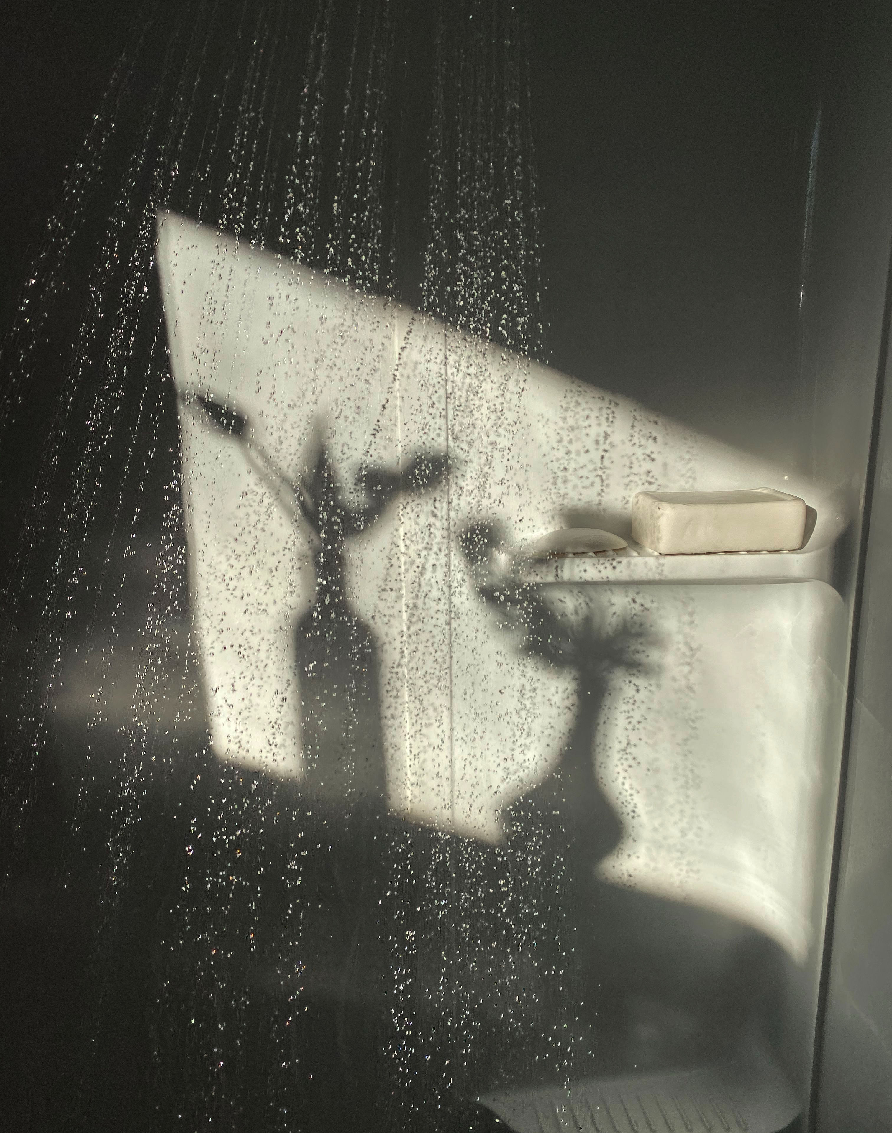Bathroom products seen through a rain-speckled glass panel